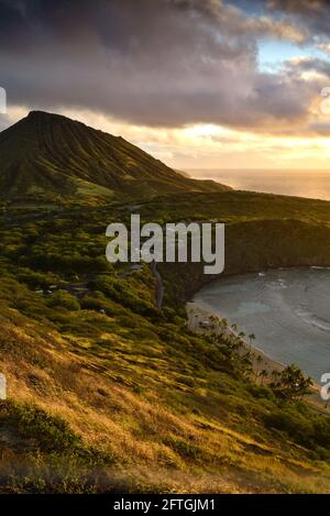 Ruhiger, ruhiger Sonnenaufgang über der Hanauma Bay, einem der beliebtesten Reiseziele für Schnorcheln und Schwimmen, und dem Koko Head Crater, Oahu, Honolulu, Hawaii, USA Stockfoto