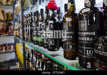 Madeira Weinflaschen auf einem Regal, umgeben von traditionellem Madeira Neuheiten Stockfoto
