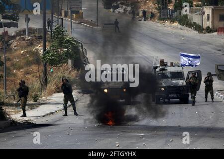 Hebron, Westjordanland-Stadt Hebron. Mai 2021. Israelische Soldaten richten ihre Waffen auf Demonstranten während eines Protestes zur Unterstützung der Palästinenser in Jerusalem und im Gazastreifen in der Stadt Hebron im Westjordanland am 21. Mai 2021. Kredit: Mamoun Wazwaz/Xinhua/Alamy Live Nachrichten Stockfoto