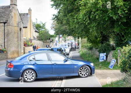 Autos stehen in der Schlange, um einen Parkplatz auf freiem Feld zu finden Das Dorf Cotswold in Bourton-on-the-Water, das eine beispiellose Besucherzahl verzeichnet Während des C Stockfoto