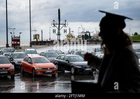 Bremerhaven, Deutschland. Mai 2021. Absolventinnen und Absolventen der Hochschule Bremerhaven nehmen an einer Abschiedszeremonie und der Verleihung von Zertifikaten in Autos auf dem Willy-Brandt-Platz Teil. Die Teilnehmer konnten die Zeremonie vom Auto aus auf einer Bühne und über einen Bildschirm verfolgen. Quelle: Sina Schuldt/dpa/Alamy Live News Stockfoto