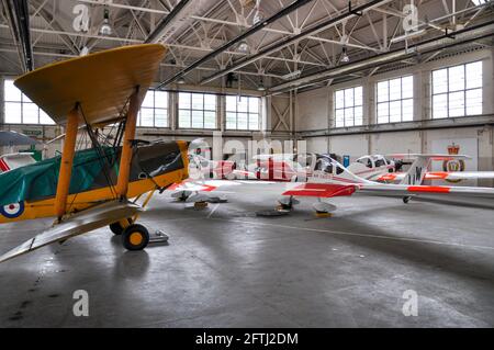 Flugzeuge, die sich in einem Hangar in RAF Halton, Buckinghamshire, Großbritannien, vor schlechtem Wetter schützen, das einen Jubiläumsflug abgesagt hat. Tiger Moth & Vigilant Stockfoto