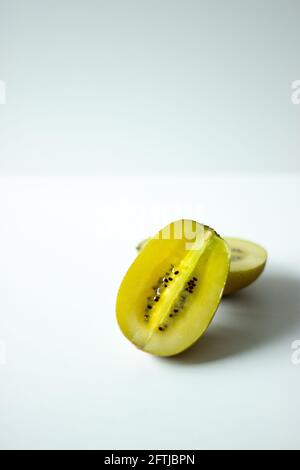 Nahaufnahme der Hälfte einer goldenen Kiwi-Frucht auf weißem Hintergrund; isolierte Kiwi; exotische Früchte Stockfoto