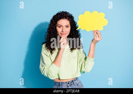 Portrait of adorable minded Lady Hand auf Kinn halten Papier Wolkenfigur isoliert auf blauem Hintergrund Stockfoto