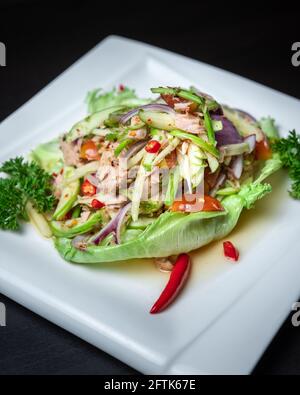 Ein Gericht aus thailändischem würzigem Thunfisch-Salat mit grünem Mango Stockfoto