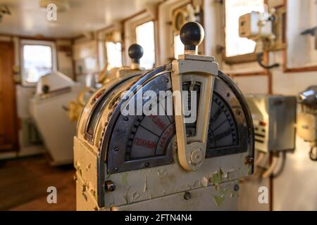 Navigationsbrücke auf verlassenen Schiff. Altes, verderbtes Schiffsradhaus. Steuergerät des Schiffs. Russische Worte: Vorwärts/achteraus, voll, halb, langsam, tot langsam Stockfoto