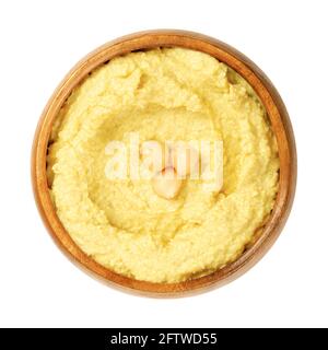 Hummus-Dip mit Kichererbsen-Garnierung in einer Holzschüssel. Nahost-Dip, Aufstrich oder herzhaftes Gericht aus gekochten, pürierten Kichererbsen. Stockfoto