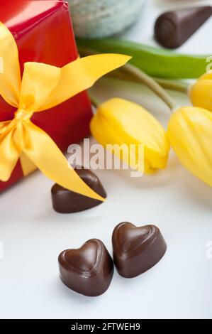 Rote Box Geschenk Geschenk in gelben Schleife verpackt, und Schokolade für Valentinstag, Ostern, Geburtstag oder Muttertag Geschenk Stockfoto