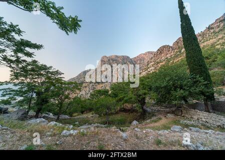 Neben der Festung von Kotor.die Ruinen umgeben diese kleine, stillvolle alte Kirche, inmitten wunderschöner Berglandslandschaften. Stockfoto