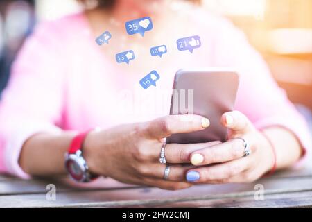 Ein Mädchen nutzt ein Smartphone, während es Zeit in sozialen Netzwerken verbringt, Likes und Abonnenten bekommt. Stockfoto