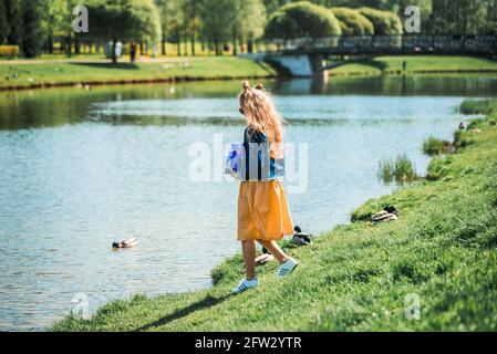 Zwei bezaubernde Schwestern füttern Enten an einem Fluss im Sommer Stockfoto