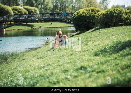 Zwei bezaubernde Schwestern füttern Enten an einem Fluss im Sommer Stockfoto