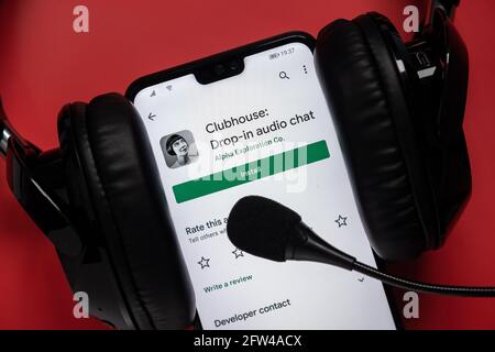 Smartphone mit Clubhouse-App im android Play-Markt und Kopfhörer mit Mikrofon um ihn herum gesehen. Konzept für Audio-Chat. Stafford, Vereinigtes Königreich, Stockfoto