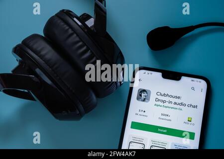 Smartphone mit Clubhouse-App im android Play-Markt und Kopfhörer mit Mikrofon um ihn herum gesehen. Konzept für Audio-Chat. Stafford, Vereinigtes Königreich, Stockfoto