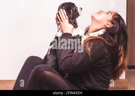 Das Teenager-Mädchen umarmt ihren Hund in ihrem Haus. Liebe für Tiere Stockfoto