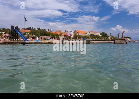 Leute, die am Strand Jaz in der Stadt Preko, Insel Ugljan, Dalmatien, Kroatien genießen Stockfoto