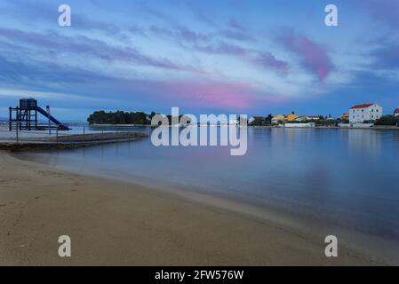 Beliebte Strand Jaz im Ort Preko bei Sonnenuntergang, Insel Ugljan, Dalmatien, Kroatien Stockfoto