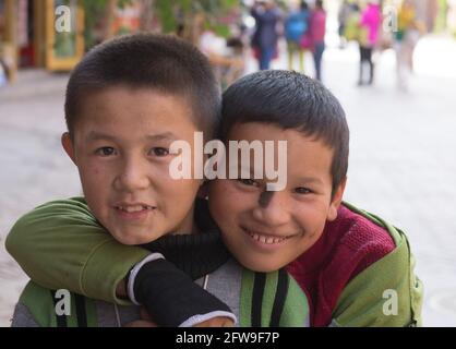 Zwei uigurische Jungen umarmten die Pose für die Fotografie Kashgar, Sinkiang, Volksrepublik China, 2019 Stockfoto