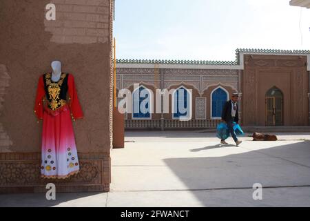 Ein traditionelles und festliches Kleid, das an einer Wand hängt. Kashgar, Xinkiang, Volksrepublik China, 2019 Stockfoto