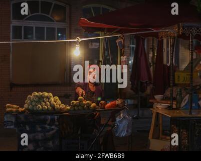 Erwachsene Frau, die Street Food in Kashgar, Xinkiang, Volksrepublik China, verkauft, 2019 Stockfoto