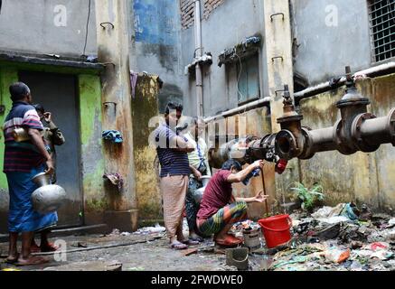 Sammeln von Wasser aus einem undichten Rohr in Dhaka, Bangladesch. Stockfoto