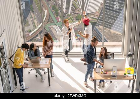 Draufsicht Szene Gruppe von asiatischen und multiethnischen Geschäftsleuten mit Casual-Anzug arbeiten und Brainstorming jede kleine Gruppe in der modernen Arbeitsplatz, div Stockfoto