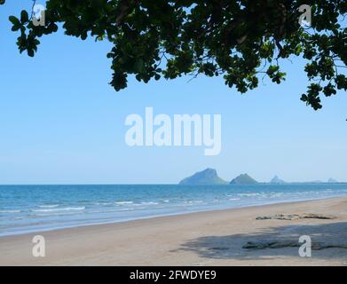 Wellenbeplanschen am Sandstrand, Blaues Wasser im Meer mit Insel, Prachuap Khiri Khan, Thailand Stockfoto