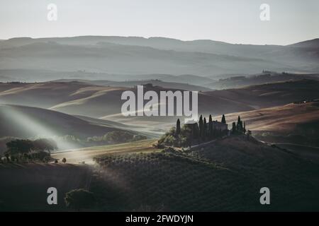 Villa Podere Belvedere in der Region Val d'Orcia in der Toskana, Italien bei Sonnenaufgang oder Morgenröte in geheimnisvoller Morgenstimmung in der Nähe von San Quirico Stockfoto