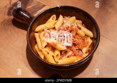 Alle Arrabiata Pasta oder Nudelgericht mit Parmesankäse penne Auf einem rustikalen Tisch Stockfoto