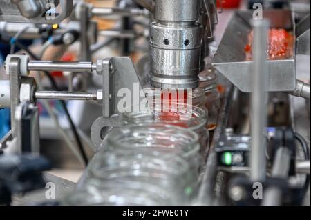 Maschine zum Befüllen von rotem Kaviar in Glasgefäße. Abfüllanlagen, Lebensmittelindustrie Stockfoto