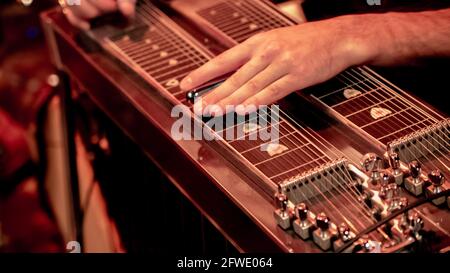 Nahaufnahme eines Musikers, der auf der Bühne Lap Steel, Pedalgitarre und Slide Guitar spielt. Stockfoto