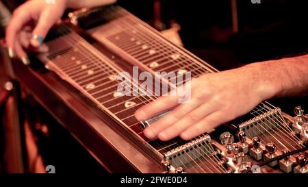 Nahaufnahme eines Musikers, der auf der Bühne Lap Steel, Pedalgitarre und Slide Guitar spielt. Stockfoto