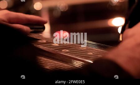 Nahaufnahme eines Musikers, der auf der Bühne Lap Steel, Pedalgitarre und Slide Guitar spielt. Stockfoto