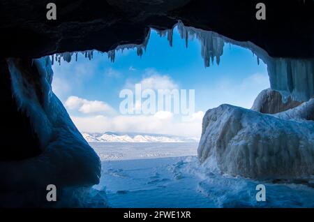 Baikalsee im Winter kalten Tag. Wunderschöne eisige Felsen mit großer Eiskruste, Eiszapfen auf den eisigen Küstenklippen der Insel Olkhon. Stockfoto