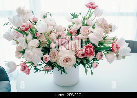 Bouquet von hellen bunten Frühlingsblumen. Weiße und rosa zarte Rosen, Tulpen und Pfingstrosen auf hellem Hintergrund. Speicherplatz kopieren. Stockfoto