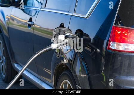 Nahaufnahme Nachfüllen des schwarzen Autos mit einem Diesel mit Gaspumpe. Stockfoto