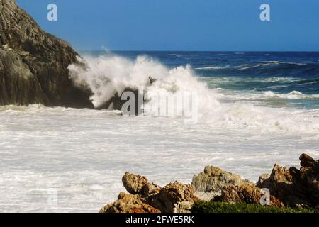 Große Wellen schlagen spektakulär gegen die steilen Klippen und zerklüfteten Küsten der Tsitsikamma-Küste in Südafrika Stockfoto
