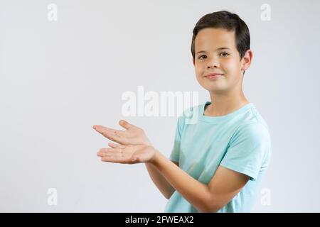 Schöne junge über isoliert weißen Hintergrund überrascht, zeigt und zeigt etwas, das auf ihrer Hand ist Stockfoto