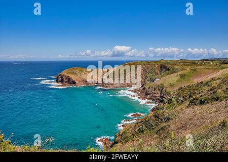 Bild der Plemont Bay bei Flut mit blauem Himmel und der Landzunge. Jersey CI. Stockfoto