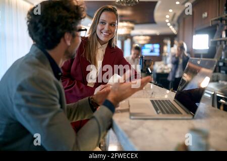 Junges kaukasisches erwachsenes Paar, das ein zwangloses Geschäftstreffen in hat Die Bar im Café Stockfoto