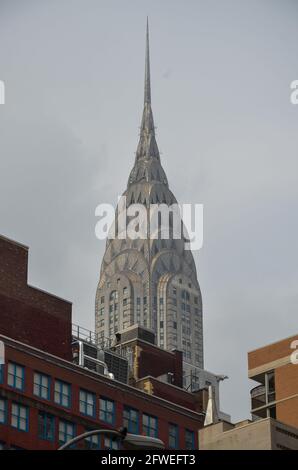 New York, USA - Juli 22 2013: Blick auf das Chrysler Building hinter einigen Häusern bei bewölktem Wetter Stockfoto