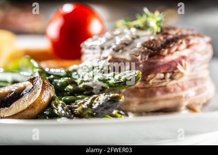 Gegrilltes Steak auf einem Teller mit Spargel, Kartoffeln und Tomaten. Stockfoto