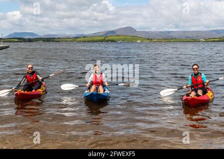 Bantry, West Cork, Irland. Mai 2021. Die Sonne schien heute Morgen auf Bantry, und viele Einheimische und Besucher nutzten das gute Wetter voll aus. Bantry Bay Boat Hire hat einen regen Handel geführt - abgebildet sind die Vorbereitungen für Kajakfahren Aoibhlinn Delany, Cork; Aileen Daly, Bantry und Marie Ruane, Cork. Quelle: AG News/Alamy Live News Stockfoto