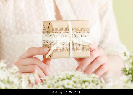 Woman Holds, ein wunderschön gewickeltes Geschenk. Geschenke für besondere Anlässe. Stockfoto