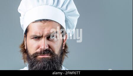 Porträt eines ernsthaften Küchenchefs. Bärtiger Koch, Köche oder Bäcker. Bärtige Köche isoliert. Kochmütze. Selbstbewusster bärtiger Chefkoch in weißer Uniform Stockfoto