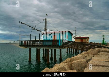 Wintermeer mit Blick auf traditionelle italienische Fischerhäuser aus Holz Stockfoto