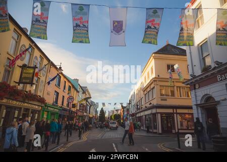 Killarney, Irland - 10 2016. September: Die geschäftige Hauptstraße mit Touristen und Einheimischen in der farbenfrohen irischen Stadt Killarney, Irland, ist auf eine Summe ausgerichtet Stockfoto