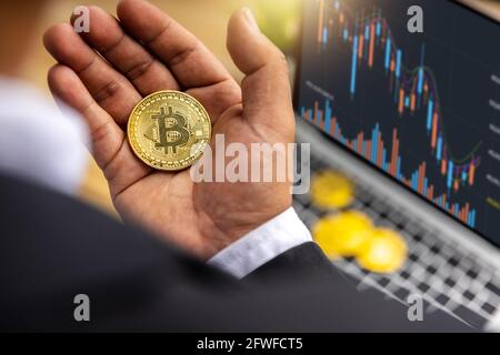 Nahaufnahme von Bitcoin in der Hand eines Geschäftsmannes, der Kryptowährung hält Gewinn und Ertrag aus Investitionen in Aktien, um Krypto zu tauschen Und bezahlen, um in f zu kaufen Stockfoto