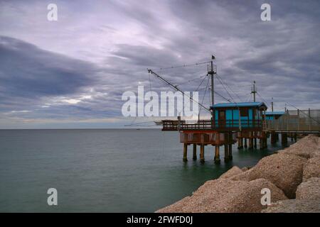 Wintermeer mit Blick auf traditionelle italienische Fischerhäuser aus Holz Stockfoto