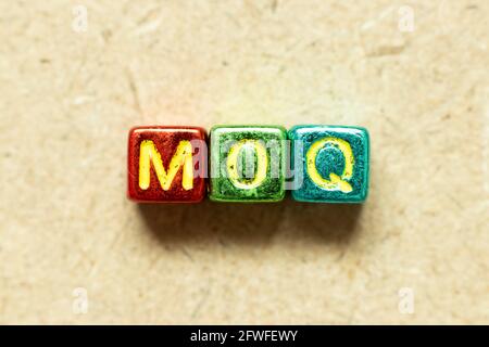 Alphabetische Buchstabenblock in Metallic-Farbe im Wort MOQ (Abkürzung für Mindestbestellmenge) auf Holzhintergrund Stockfoto